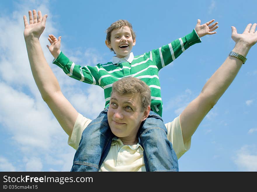 Father and his son against the blue sky