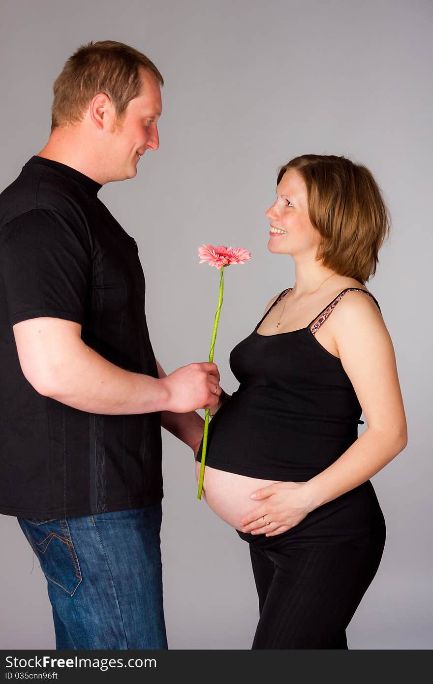 Pregnant woman with flower and her husband. Pregnant woman with flower and her husband