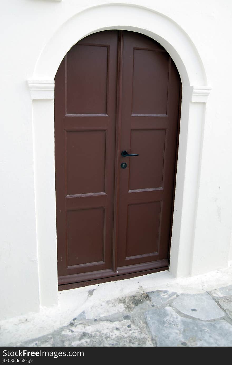 Brown door on the background of a stone wall