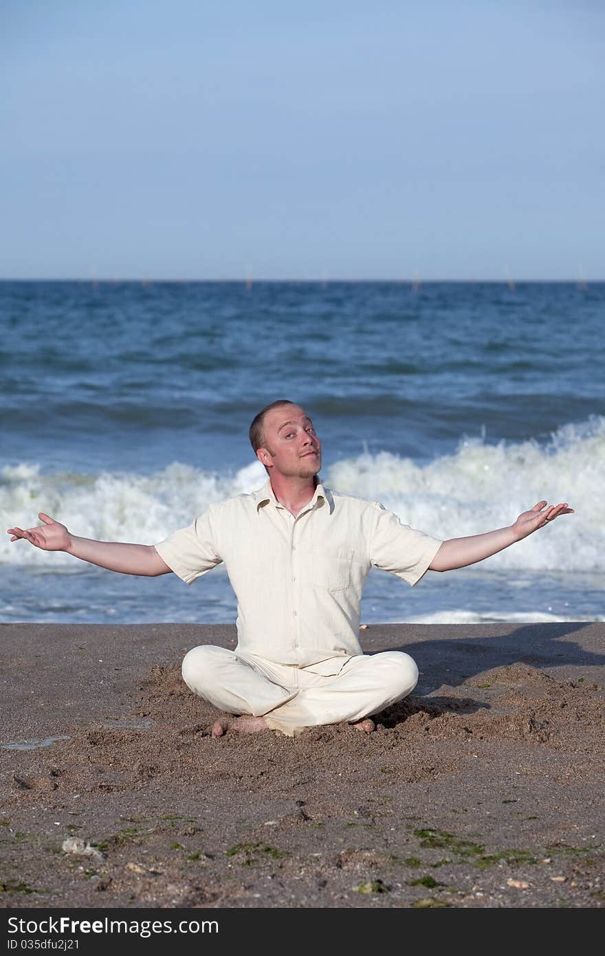 Young Businessman Doing Yoga On A Beach