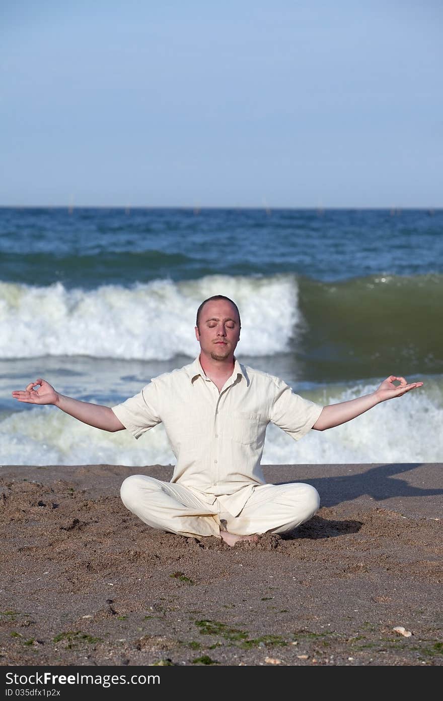 Young businessman doing yoga on a beautiful beach. Young businessman doing yoga on a beautiful beach