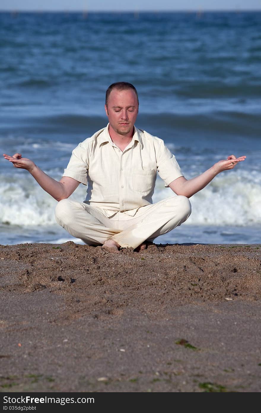 Young businessman doing yoga on a beautiful beach. Young businessman doing yoga on a beautiful beach