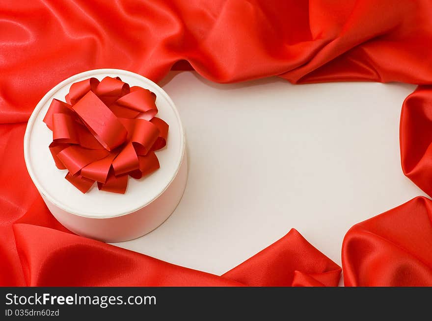 Box with a gift on a red fabric still life