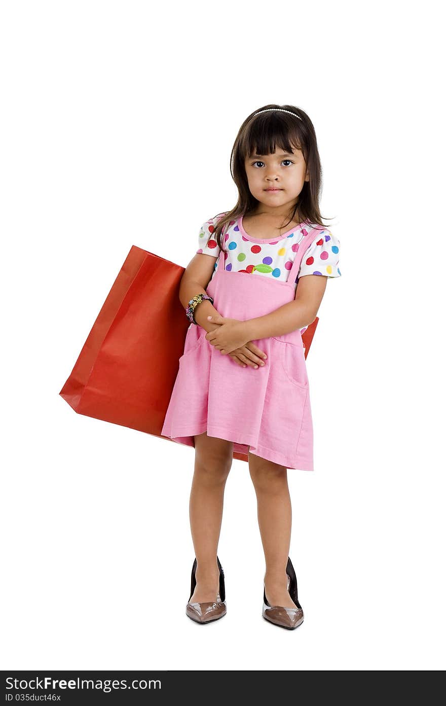 Cute little girl with shopping bag and oversized shoes, isolated on white background. Cute little girl with shopping bag and oversized shoes, isolated on white background