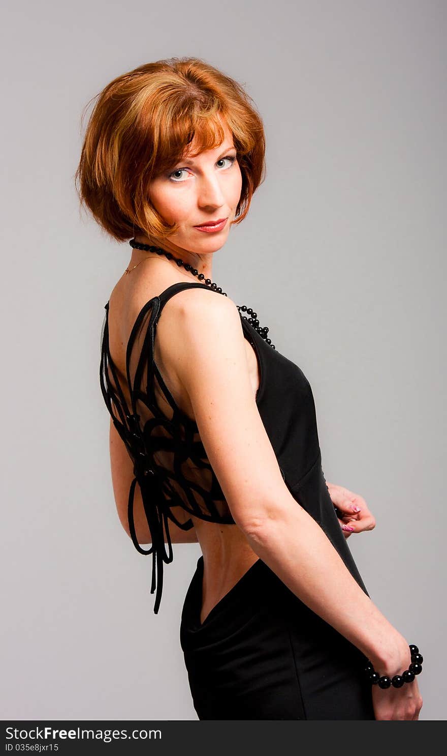 Charming young woman in a black dress in studio. Charming young woman in a black dress in studio