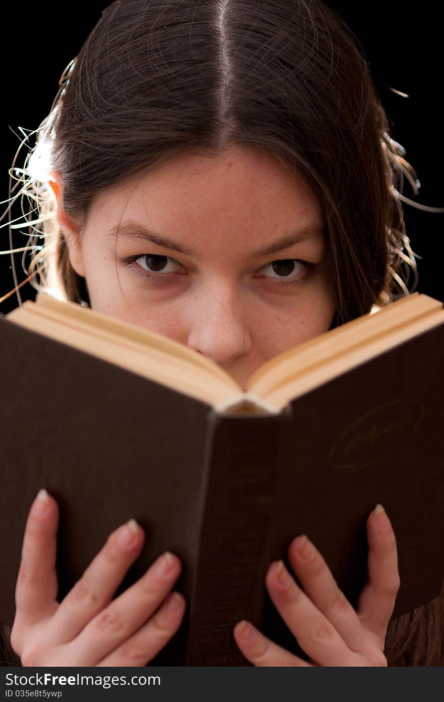 Charming young woman looking above a book. Charming young woman looking above a book