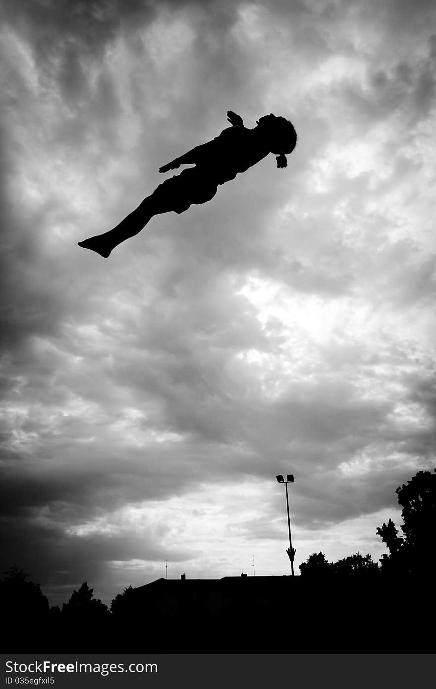 Silhouette Of Gymnast On Trampoline In Sky