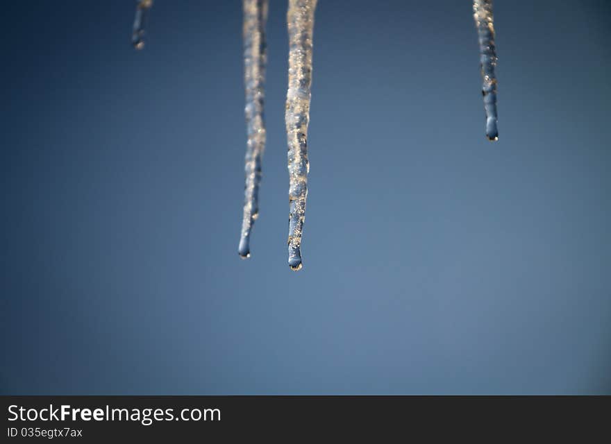 Icicle in blue sky and waterdrops