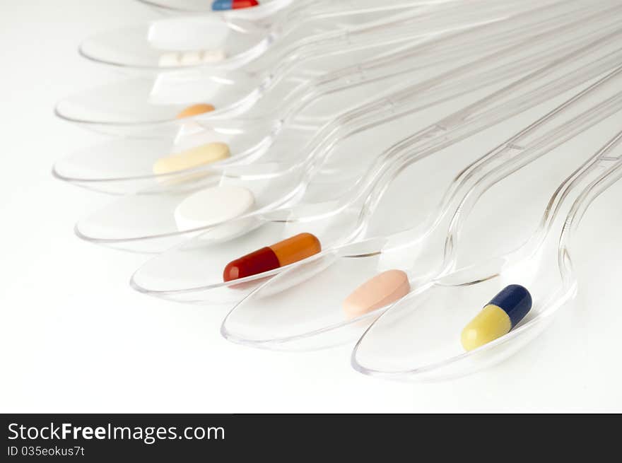 Pills in clear plastic spoons