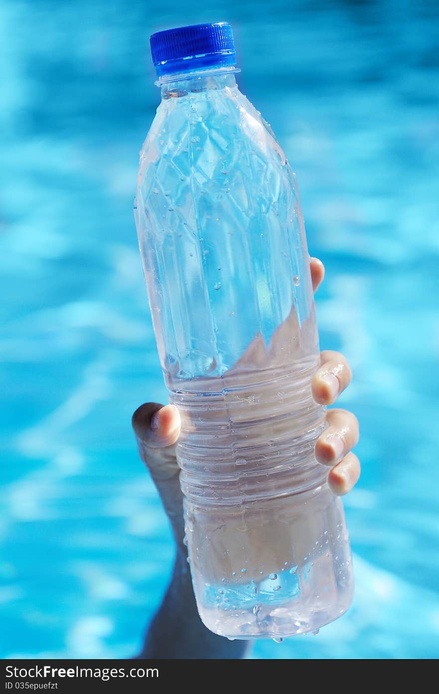 Bottle of water in a hand against water