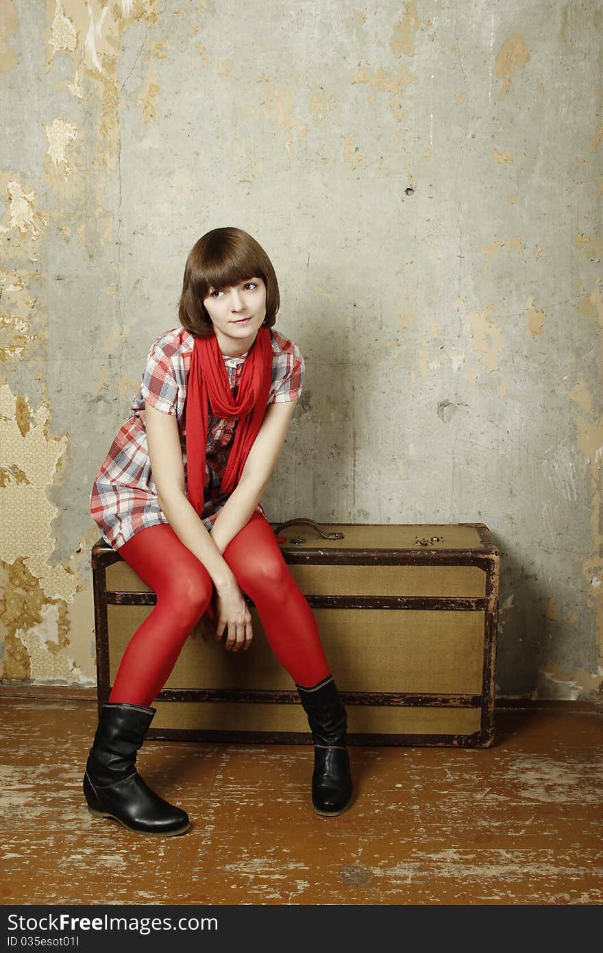 Attractive woman sitting on a suitcase