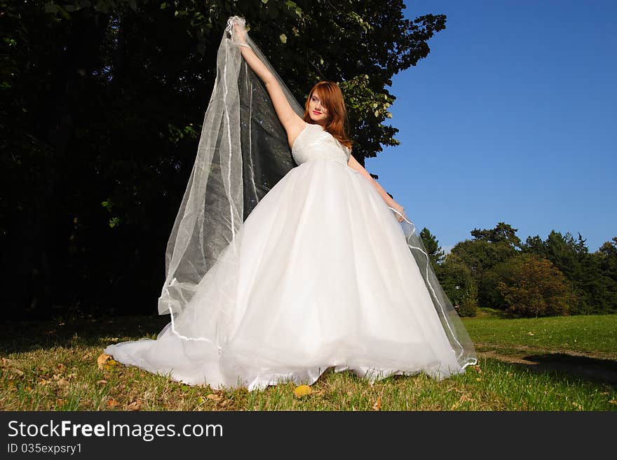 Young beautiful woman posing in a white dress in the nature. Young beautiful woman posing in a white dress in the nature