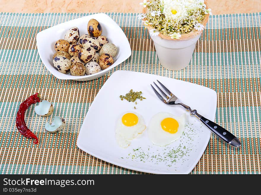 Quail eggs, as eggs, fried, on a white plate.