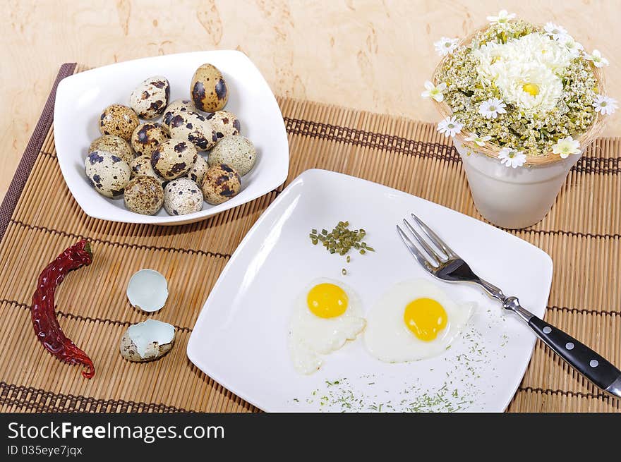 Quail eggs, as eggs, fried, on a white plate.