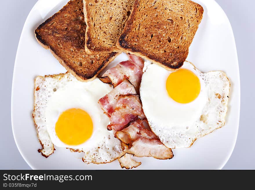 Breakfast - roasted toasts, eggs, bacon. Breakfast - roasted toasts, eggs, bacon