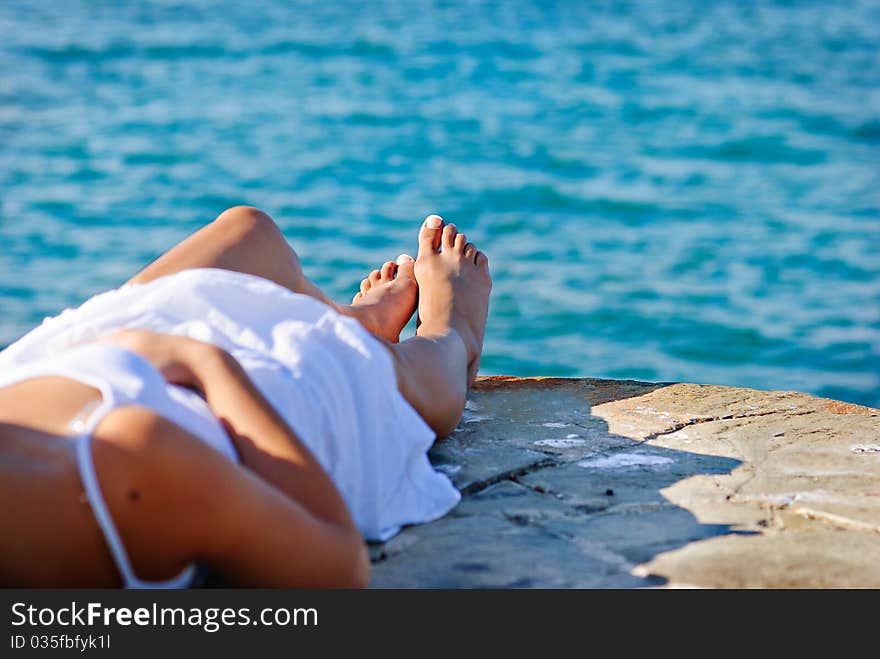 Girl in white dress is resting next to the sea. Girl in white dress is resting next to the sea