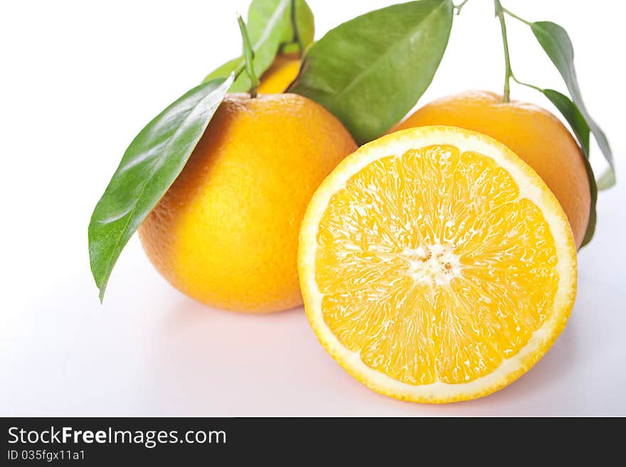 Ripe oranges with leaves, isolated on a white.