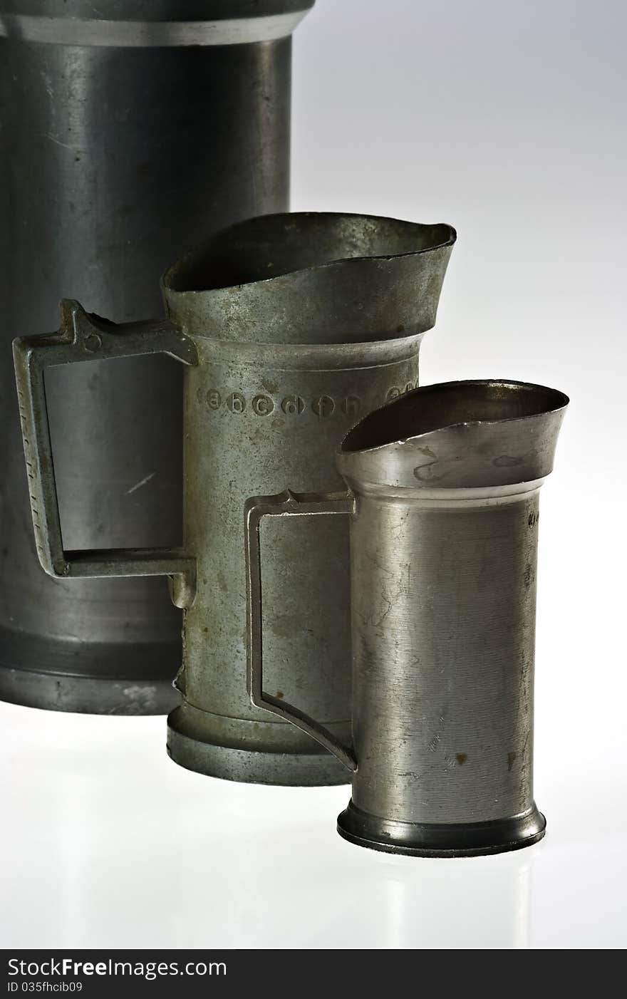 Old tin measuring vessels on white background