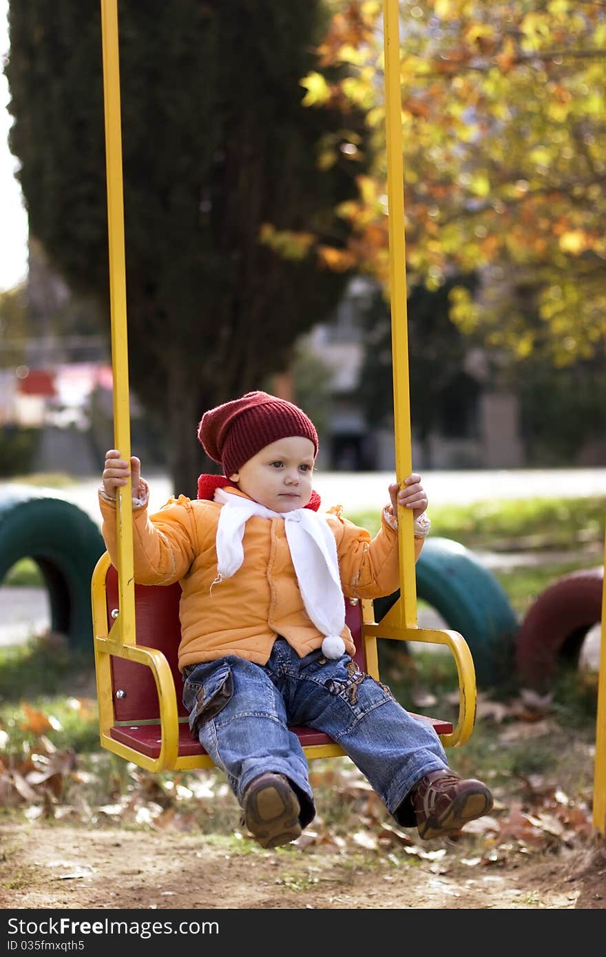 Little girl sitting on the roundabout.