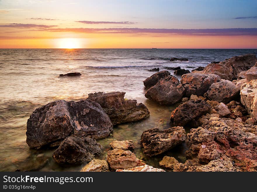 Beautiful seascape. Sea and rock at the sunset. Nature composition.