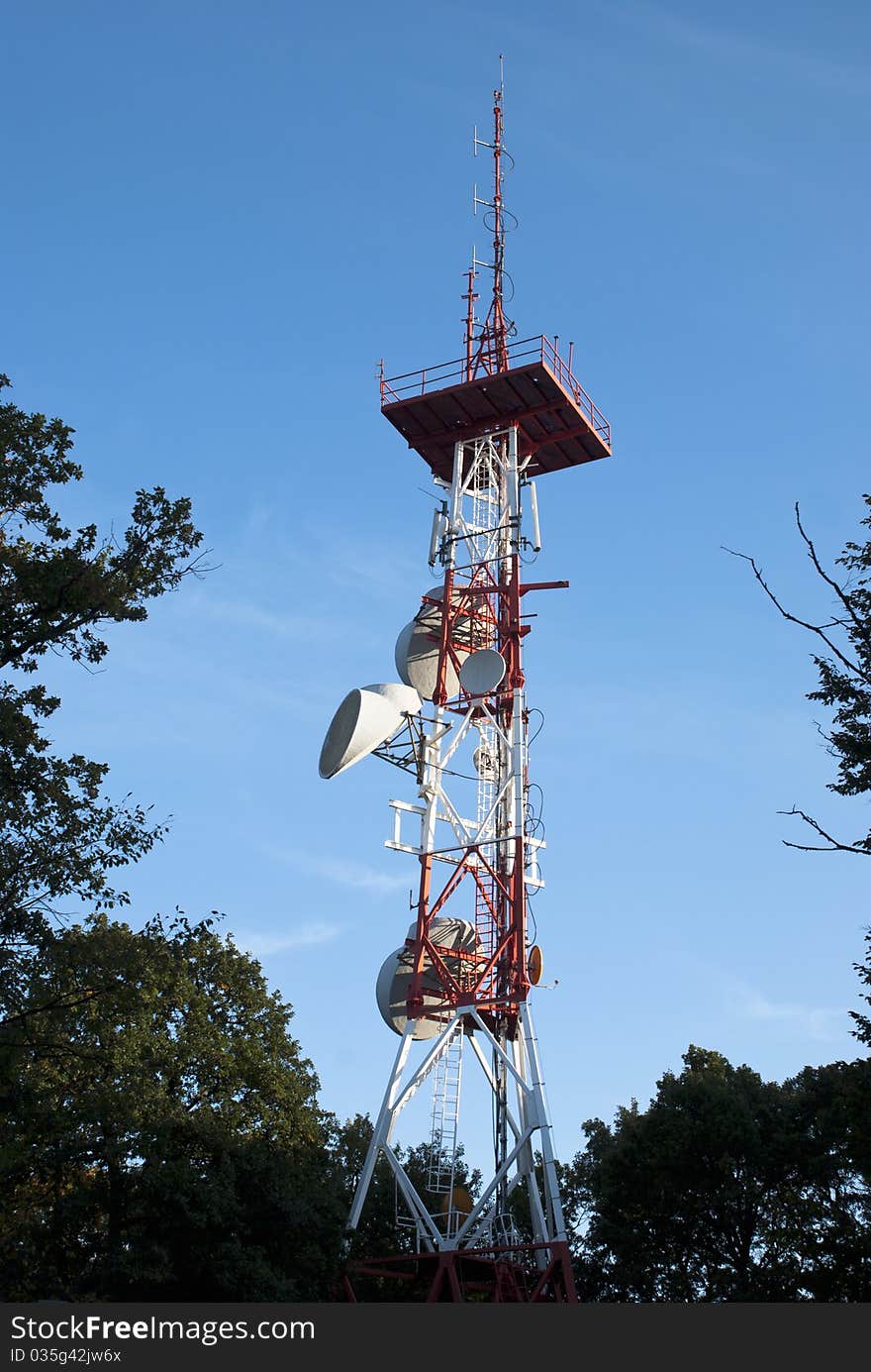 Huge communication antenna surrounded by trees. Huge communication antenna surrounded by trees.
