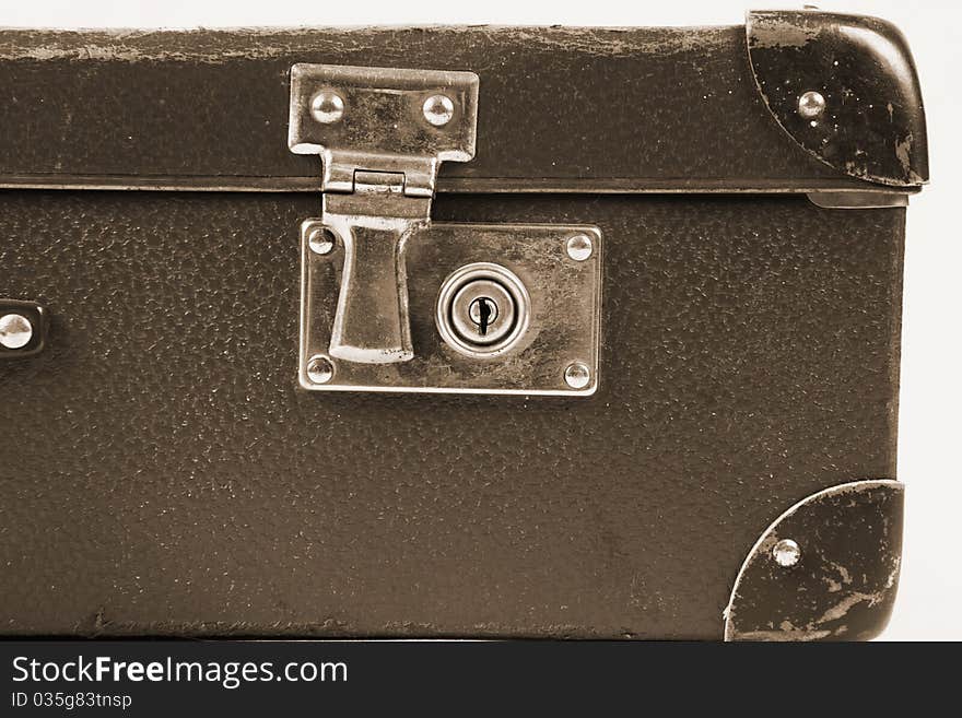 Vintage suitcase with a lock in sepia in close up