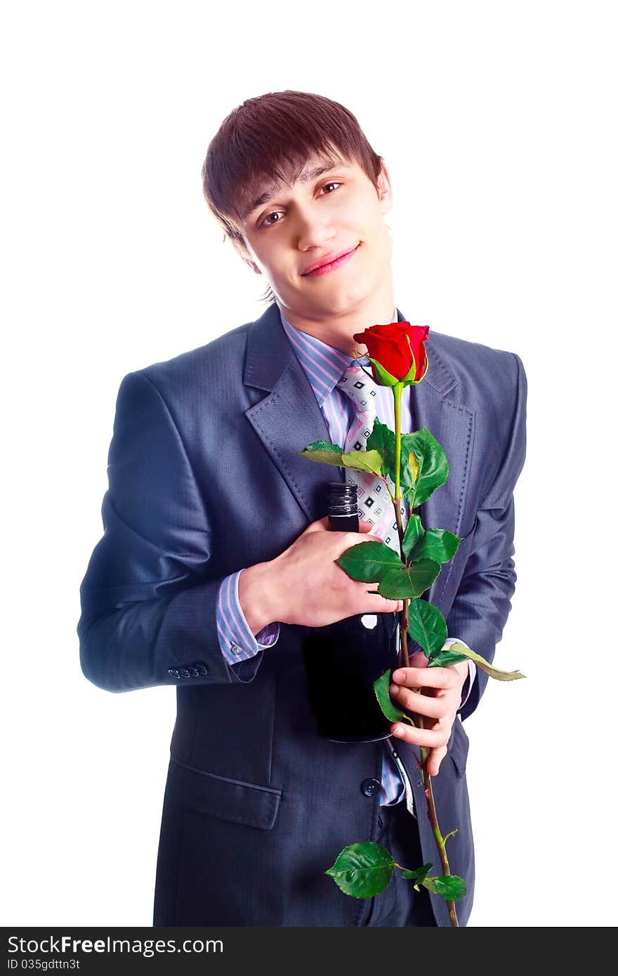 Handsome young man with a red rose and a bottle of brandy. Handsome young man with a red rose and a bottle of brandy