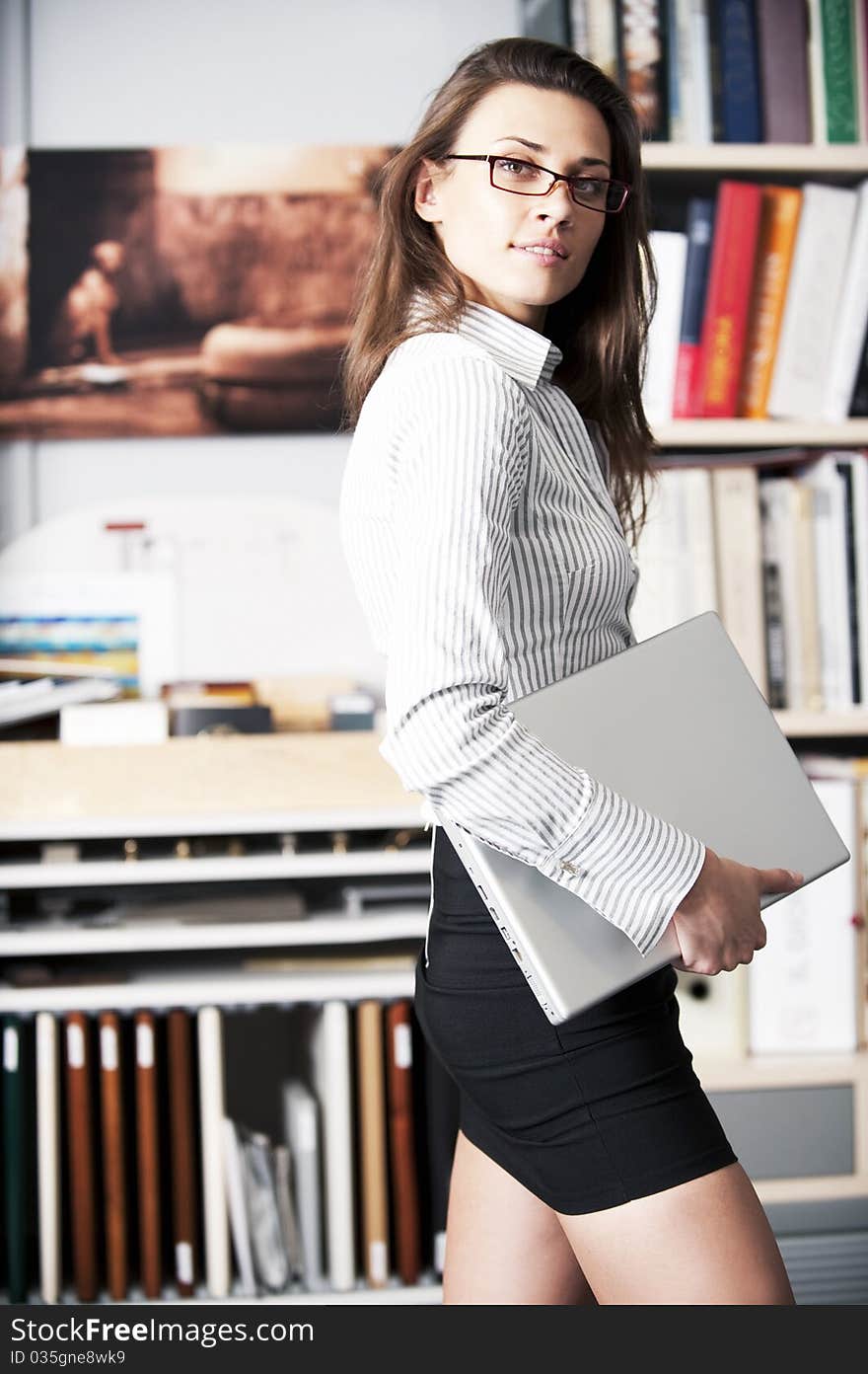 Young Women Stands Near Bookshelf