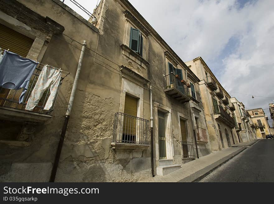 Tipical Street in Sicily (italy), ancient building and clothes on balcony