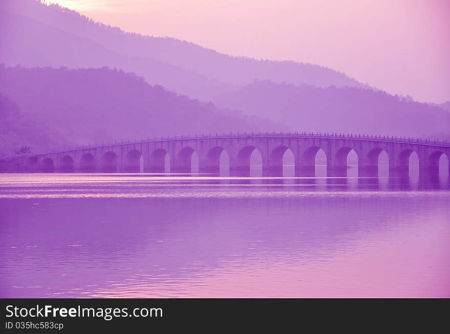 Stone arch bridge at the mountain foot in rosy sunset,guangzhou,guangdong,China. Stone arch bridge at the mountain foot in rosy sunset,guangzhou,guangdong,China.