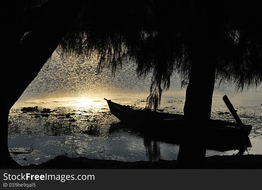 Silhouette of boat on a lake at evening glow