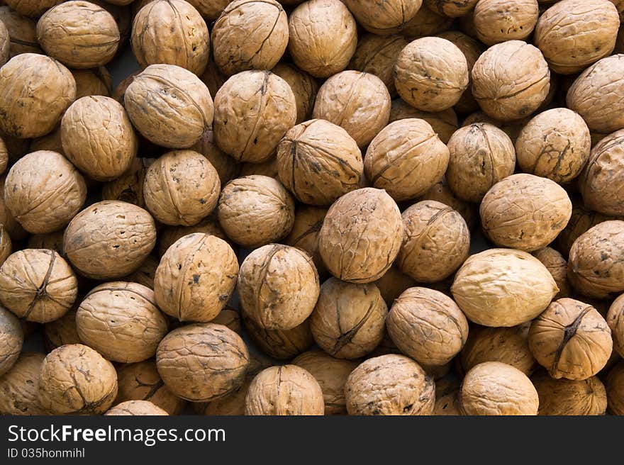 Closeup of brown raw walnuts background