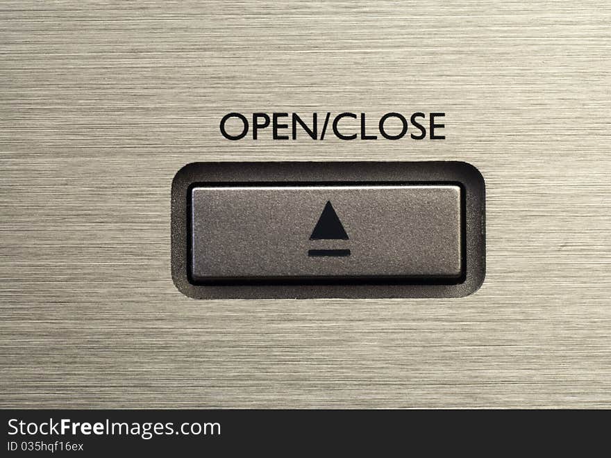 Close up of Open/ Close button on brushed metal background