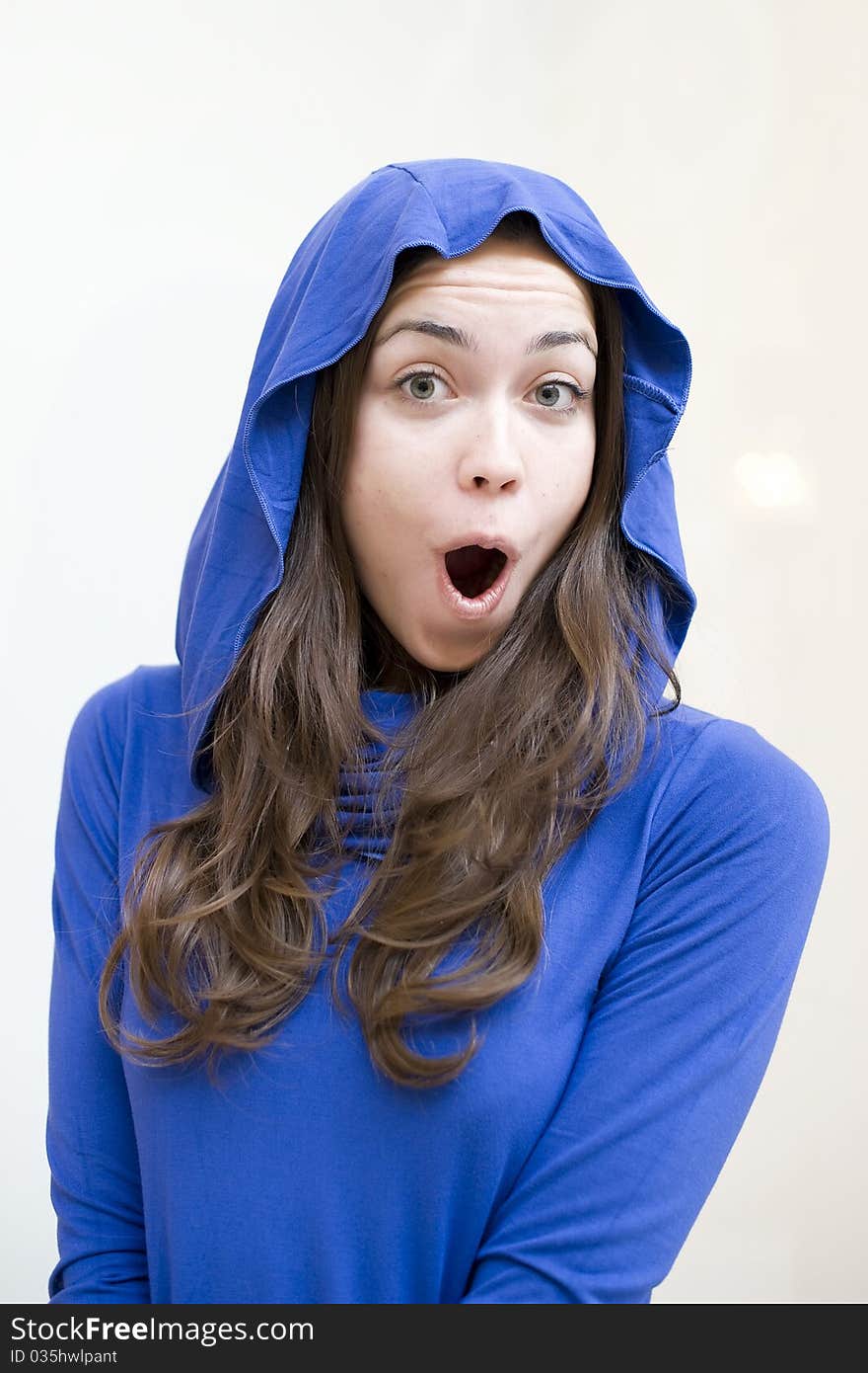 The happy young woman in brightly dark blue jacket is shocked surprise