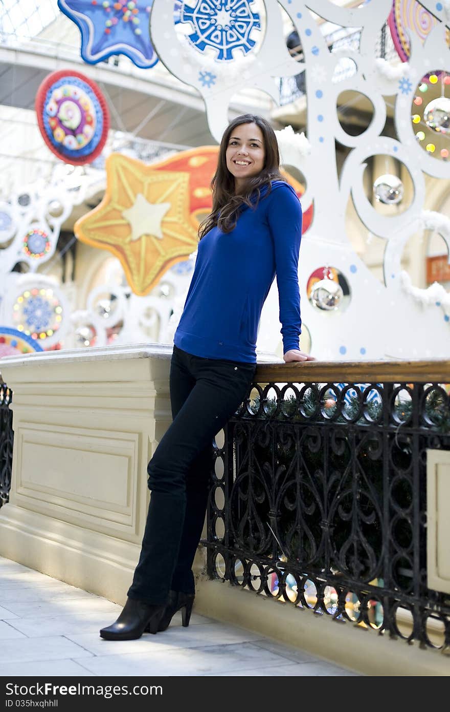 The young woman the brunette in a dark blue jacket has leaned against a handrail