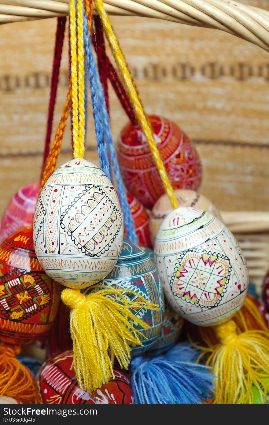 Easter eggs hang on the basket handle. Easter eggs hang on the basket handle