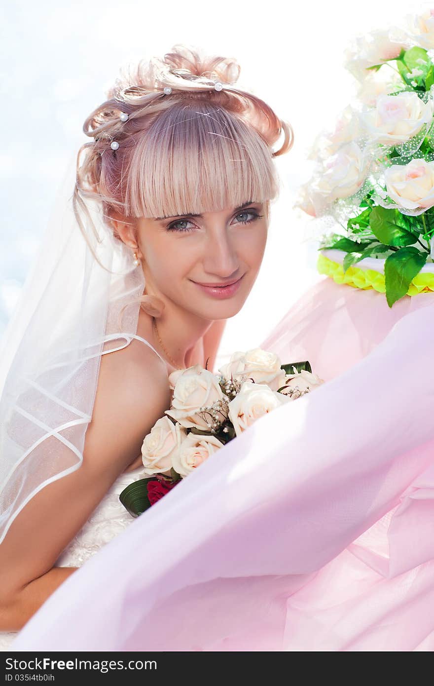 Pretty young bride posing to camera with flowers. Pretty young bride posing to camera with flowers