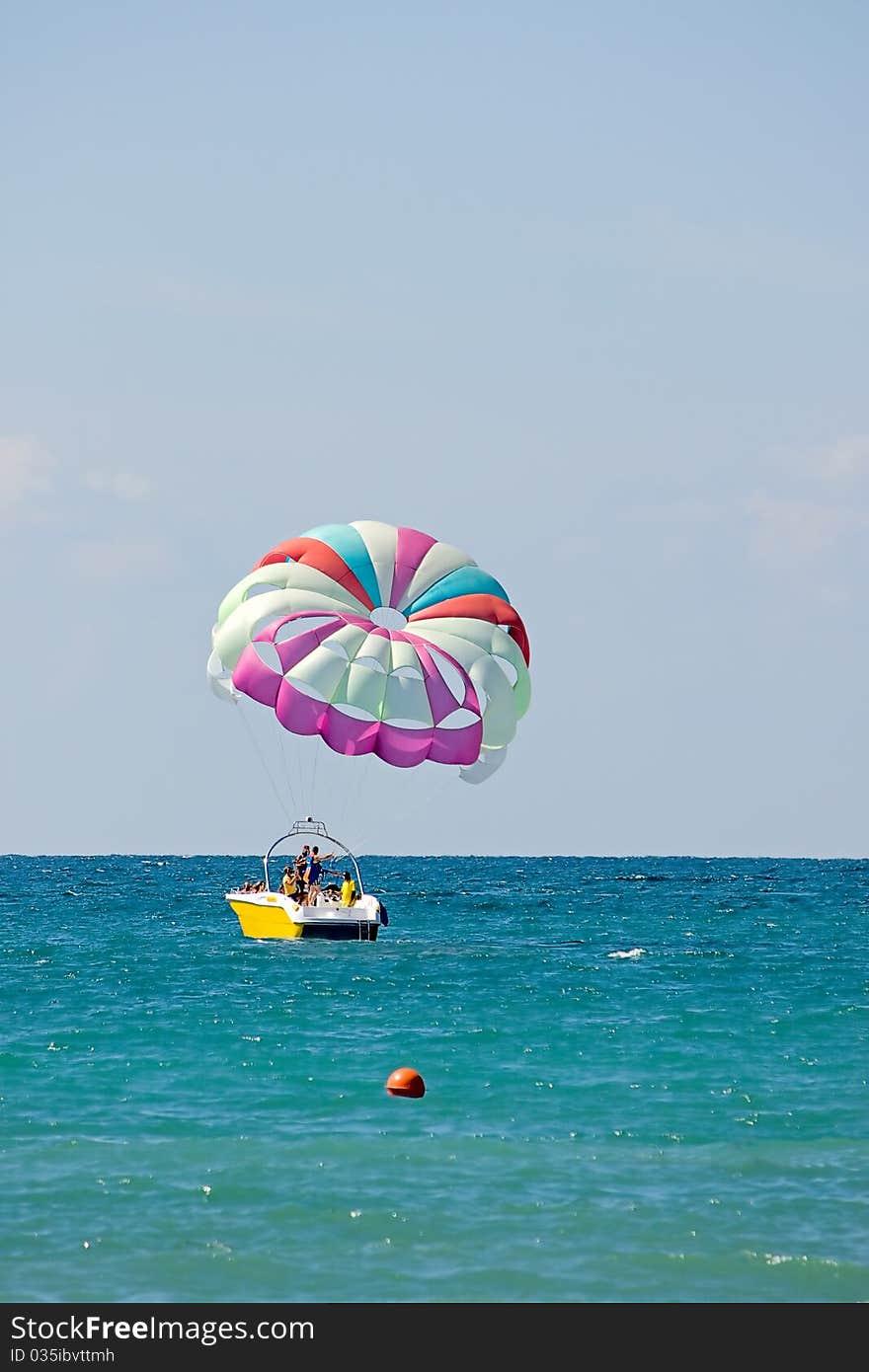 Motor boat with parachute for parasailing on background of sky and horizon.