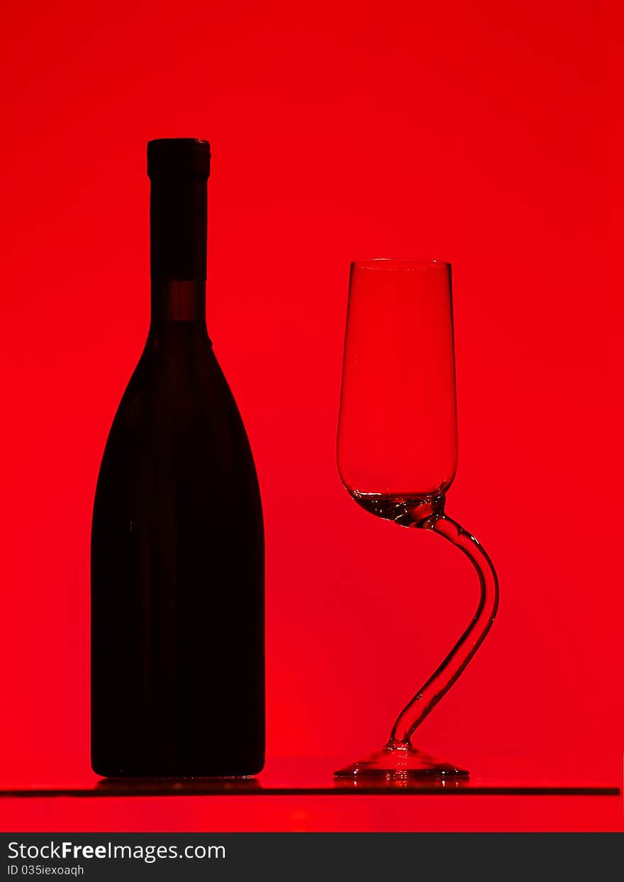 Bottle and glass over red background. Bottle and glass over red background