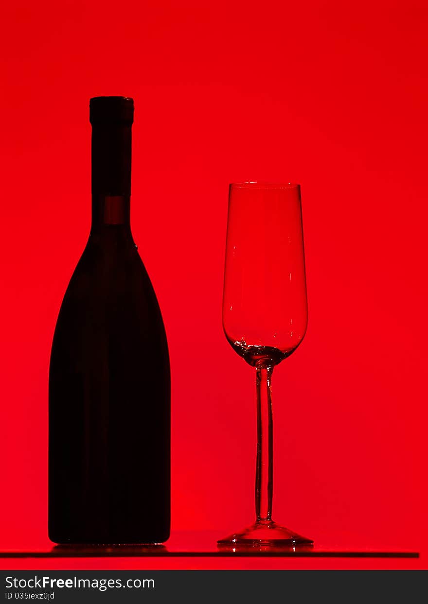 Bottle and glass over red background. Bottle and glass over red background