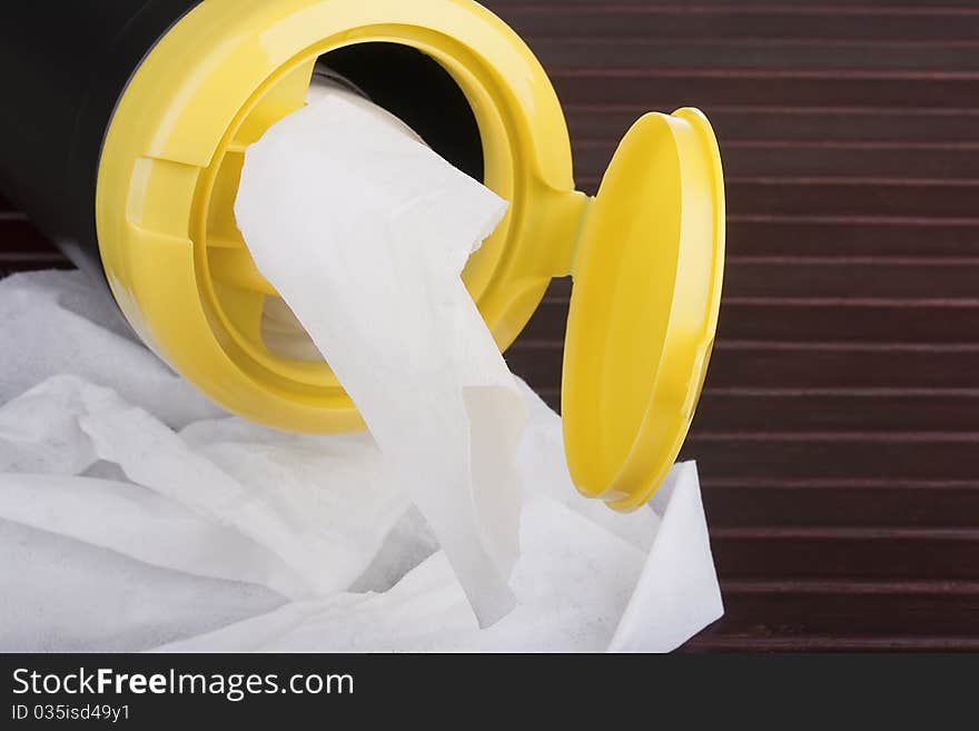 Napkin for cleaning in a plastic container with a wood background. Napkin for cleaning in a plastic container with a wood background.