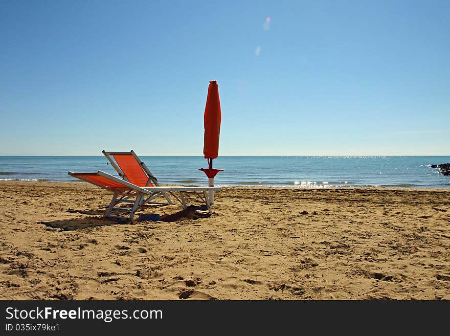 Sunshade and sun-lounger on the beach