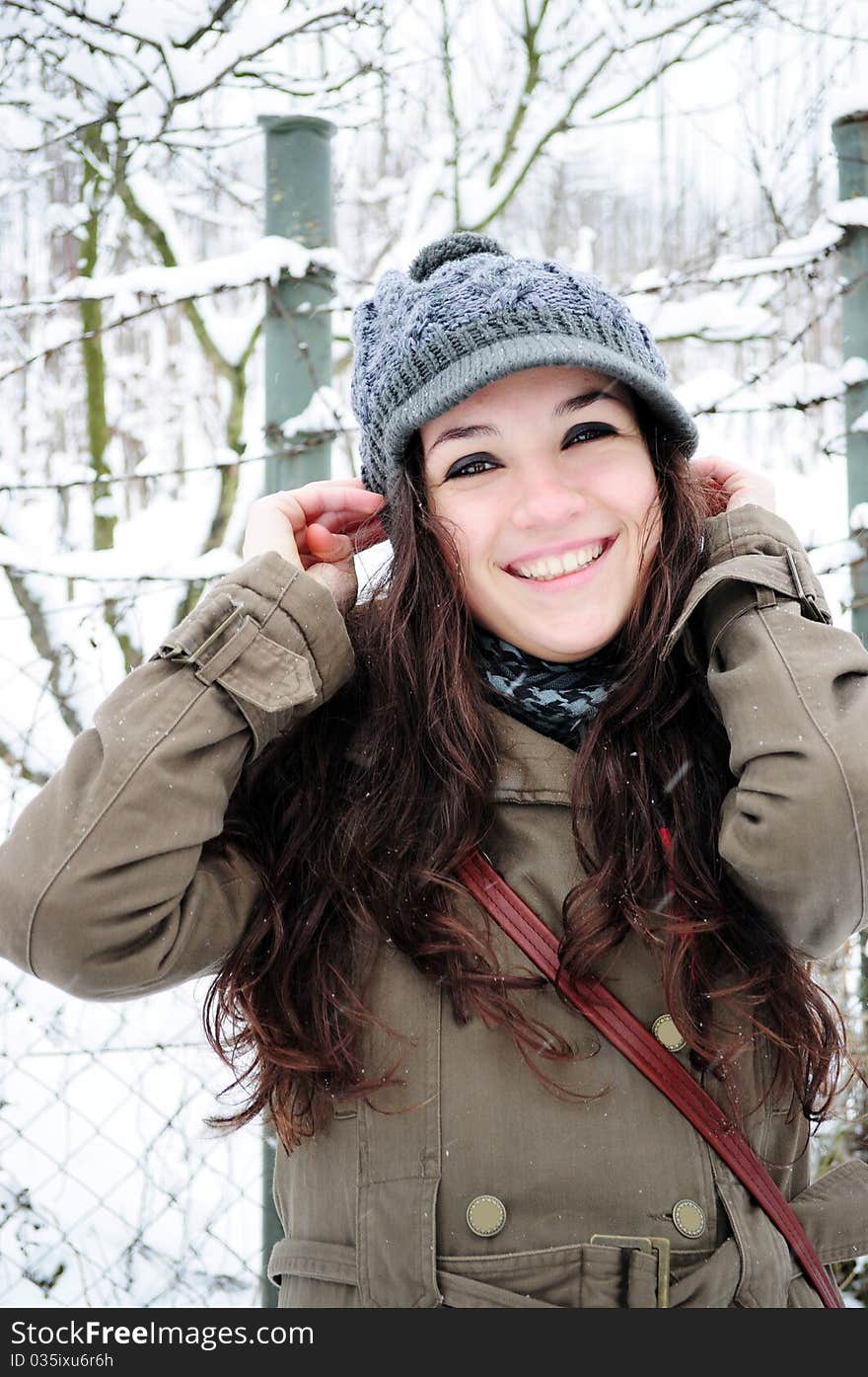 Attractive young girl laughing outside in the winter park. Attractive young girl laughing outside in the winter park