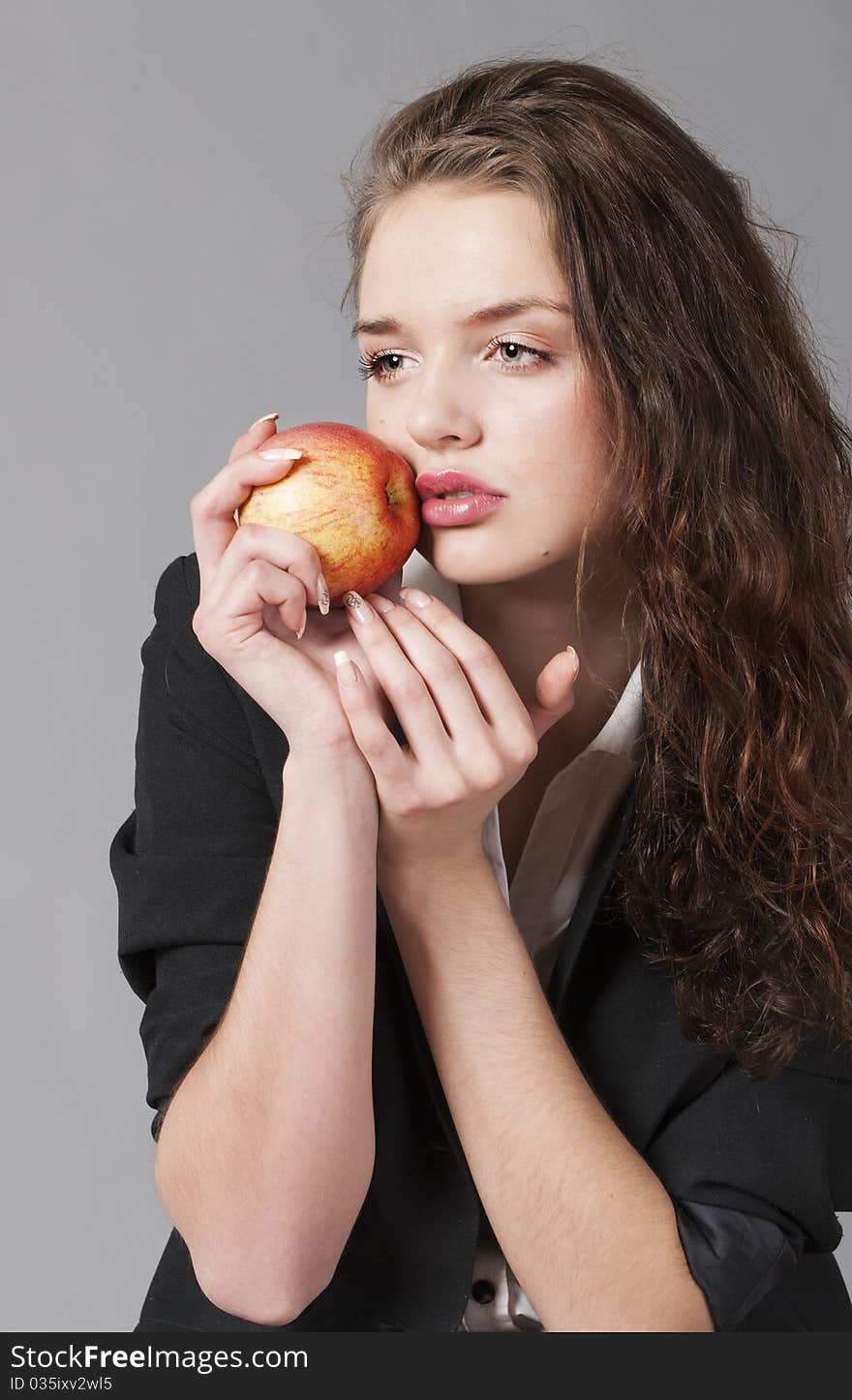 Portrait of the young girl in strict clothes with a red apple