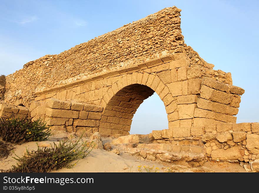 Sundown at old Ancient Roman aqueduct in Ceasarea at the coast of the Mediterranean Sea, Israel