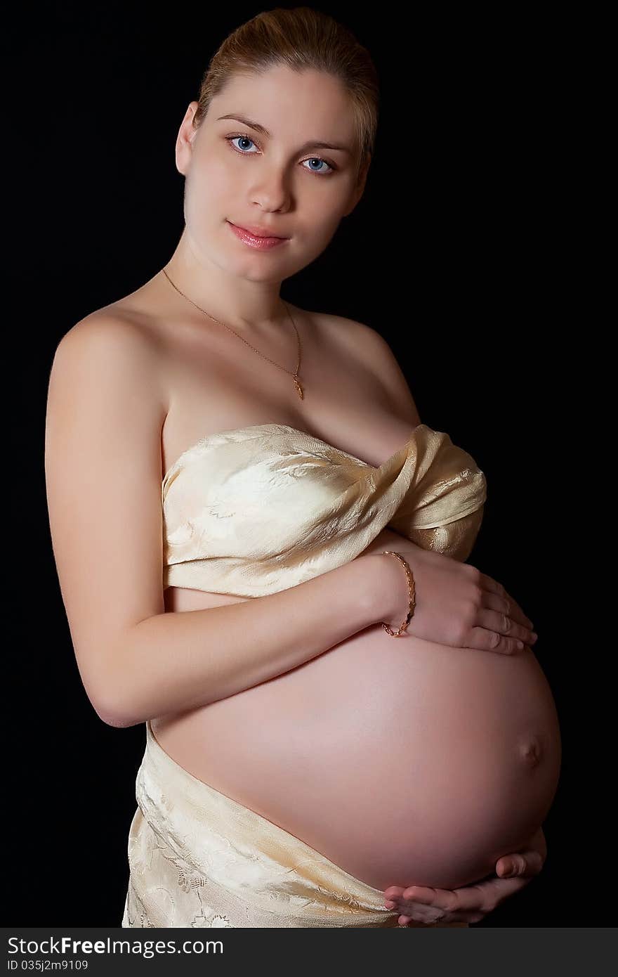 Portrait of a beautiful pregnant woman on a black background