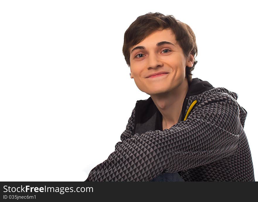 Happy young man sitting looking at camera and smiling on white background. Happy young man sitting looking at camera and smiling on white background