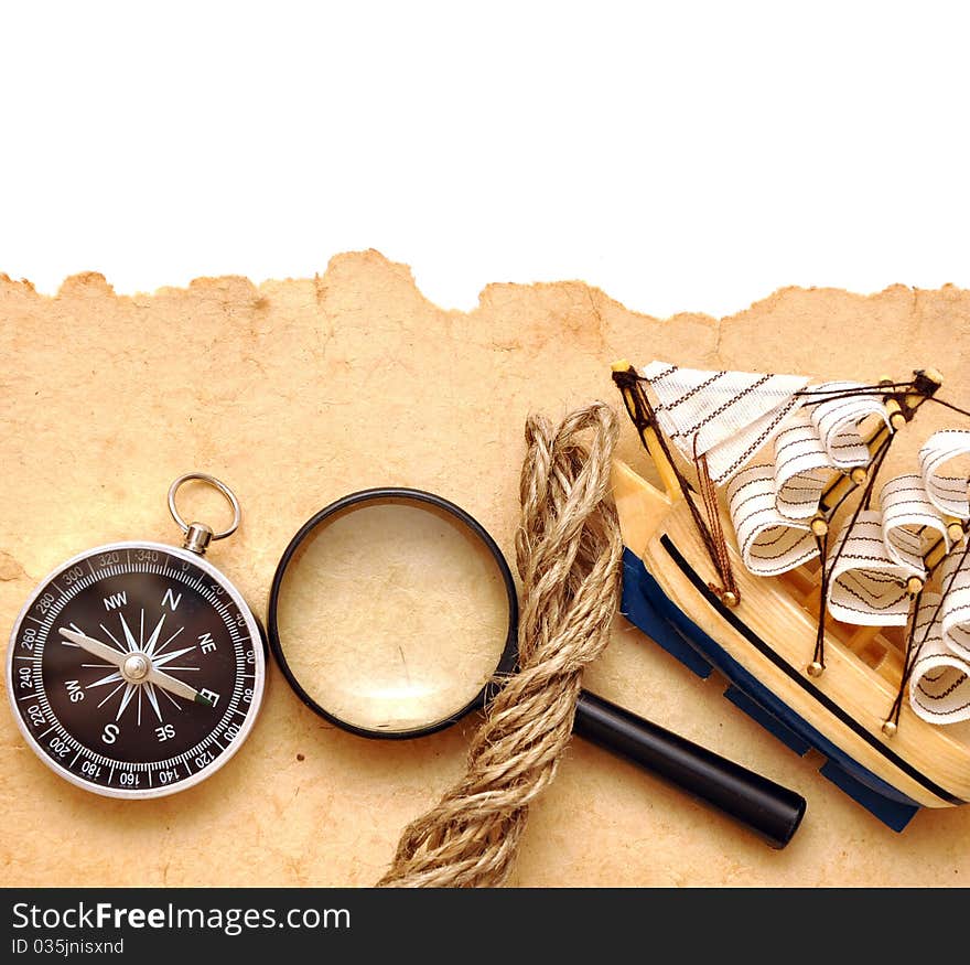 Rope, loupe, compass and model classic boat on old paper