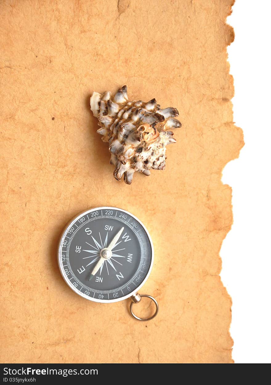 Compass and seashell on old paper