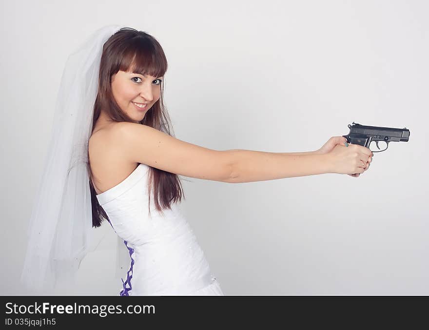 Beauty young bride in white dress holding the gun. Beauty young bride in white dress holding the gun